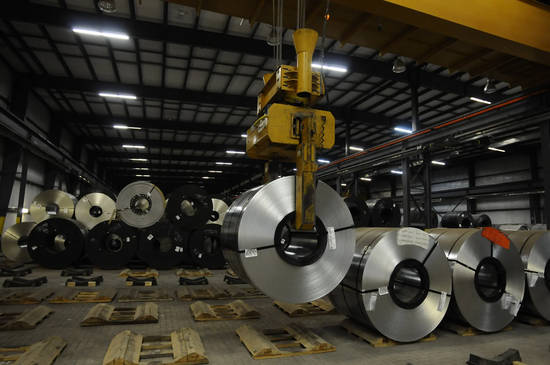 Overhead crane working above steel coils in storage